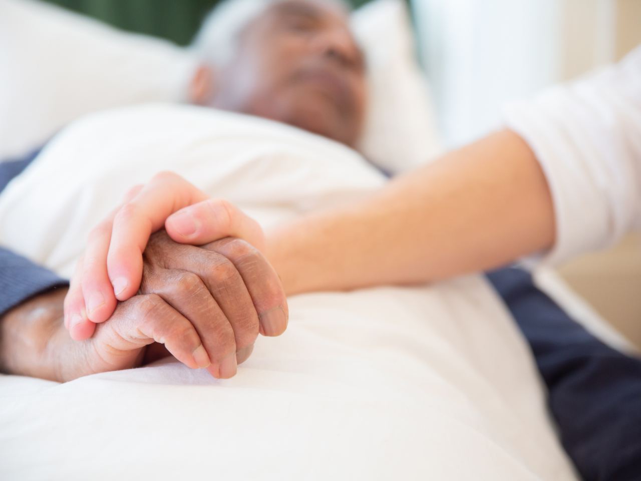 Holding the hand of a person in care
